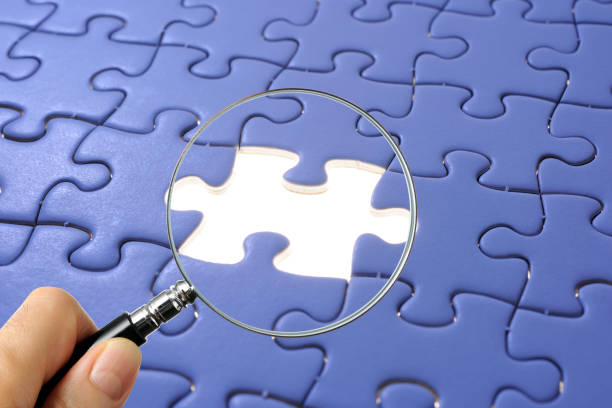 istock Search for missing last puzzle piece with magnifying glass 1207392203