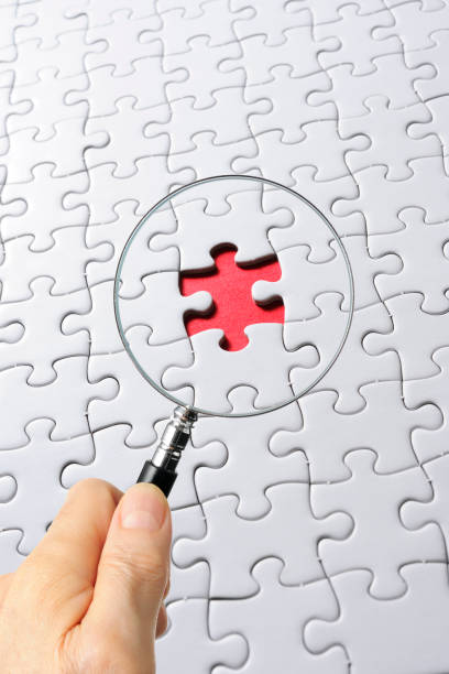 istock Search for missing last puzzle piece with magnifying glass 1207392211