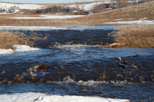 Creek with two water falls in the spring thaw of the prairie of North Dakota.