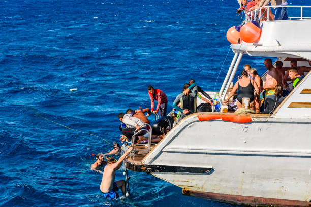 люди проводят время на белой яхте в красном море недалеко от города хургада, египет - editorial sea white ship стоковые фото и изображения