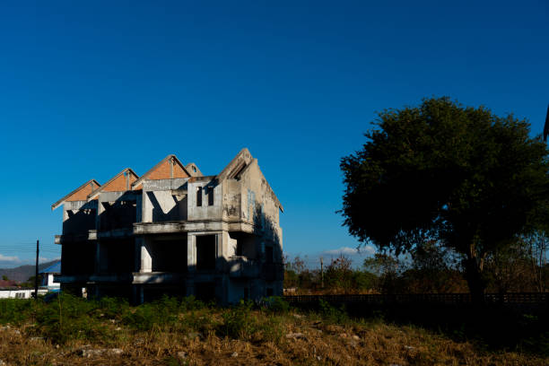 Abandoned building and tree on blue sky background.