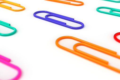 Close-up of multi-colored paper clips on a white background