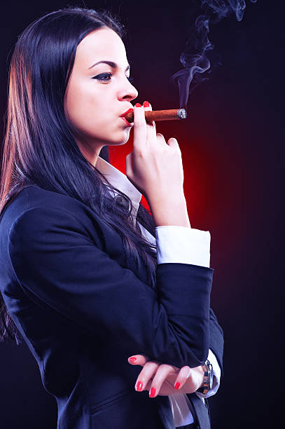 Beautiful elegant young woman with cigar stock photo