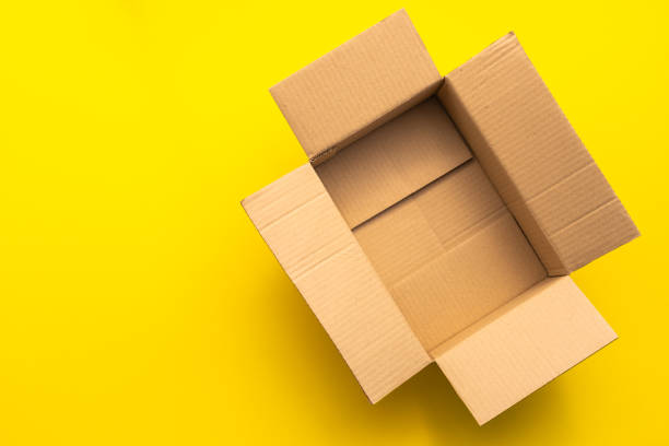 istock Top view empty brown post or carton box on yellow paper background 1207413412