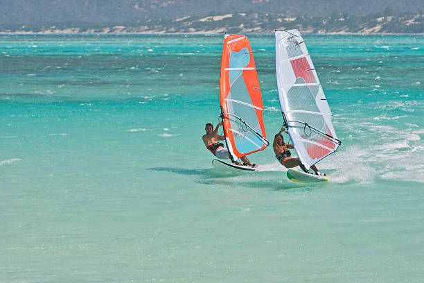 Windsurf in the lagoon Man and women windsurfing in the lagoon windsurfing stock pictures, royalty-free photos & images