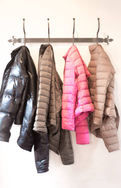 istock Four Colorful Padded Winter Jackets Hanging on Rack 1207423171