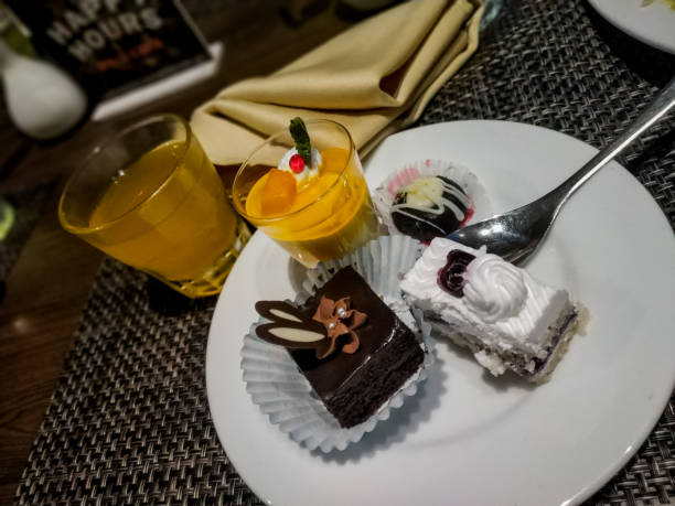 istock group of deserts after dinner with orange and mango juice. 1207424564