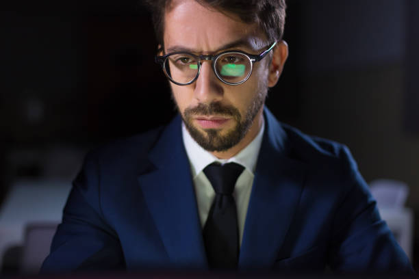 istock Handsome young businessman working with laptop at night 1207432792
