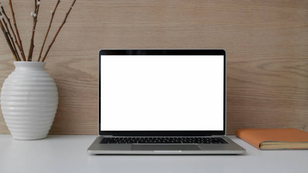 istock Close up view of workplace with  mock up laptop, notebook and ceramic vase 1207432948