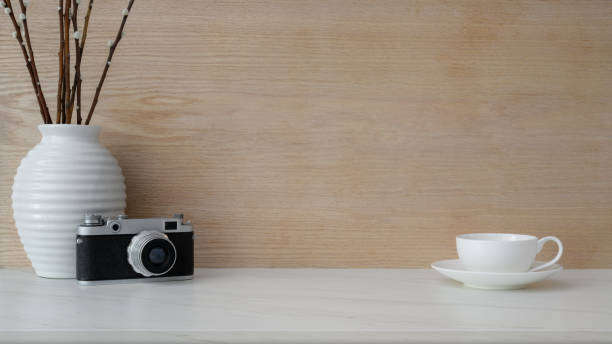 istock Close up view of workplace with copy space, coffee cup, camera and ceramic vase 1207432949
