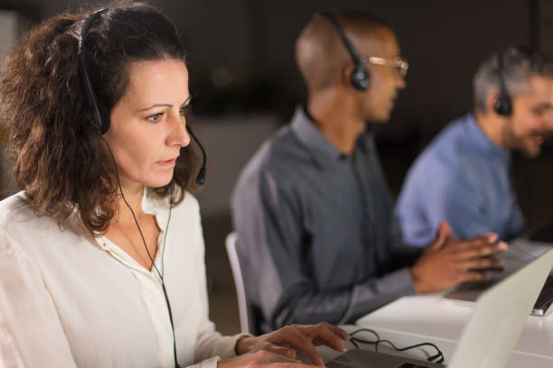 operador de call center maduro focado olhando para a tela do laptop - pensive women business mature adult - fotografias e filmes do acervo