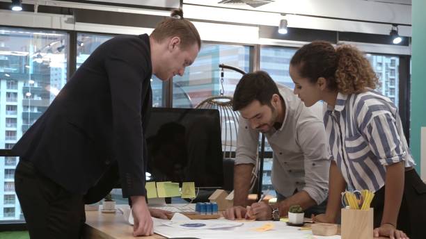 istock Creative business people group having conversation at office desk in workplace. 1207437723