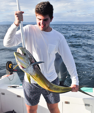 Young fisherman captures a mahi in Costa Rica