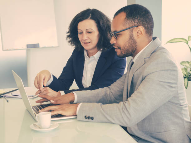 istock Female mentor teaching male newcomer 1207441376