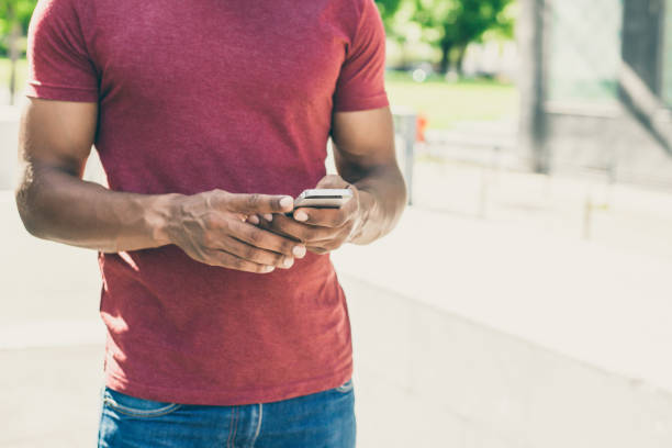 istock Handsome well built man standing outside and using smartphone 1207441693