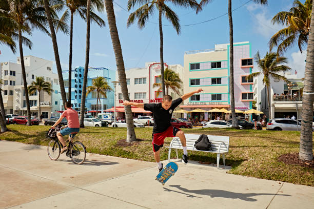 конькобежец делает трюк в ocean drive, майами, флорида, сша - florida mid air miami florida people стоковые фото и изображения