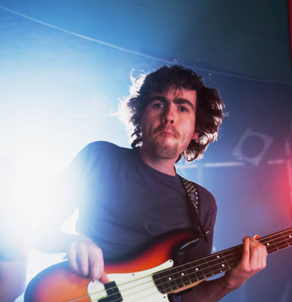 istock Rock guitarist bites lip in concentration, playing on stage 1207448012