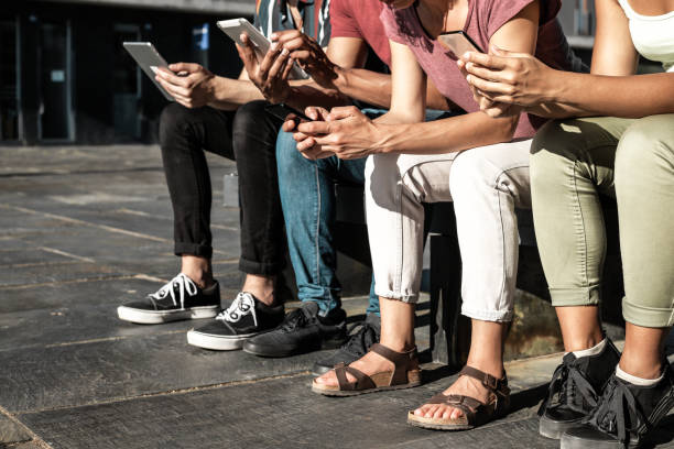 istock Group of people using gadgets outdoors 1207448580