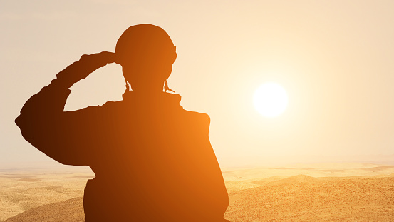 Silueta de un solider saludando contra el amanecer en el desierto de Oriente Medio. Concepto - fuerzas armadas de eau, Israel, Egipto photo