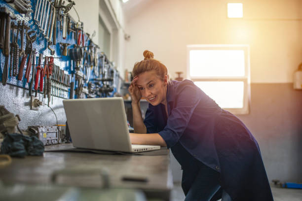 istock Mechanic using laptop at the repair garage 1207453424