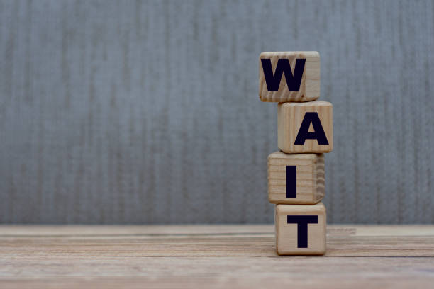 istock concept word wait on vertical cubes on a gray background 1207453478