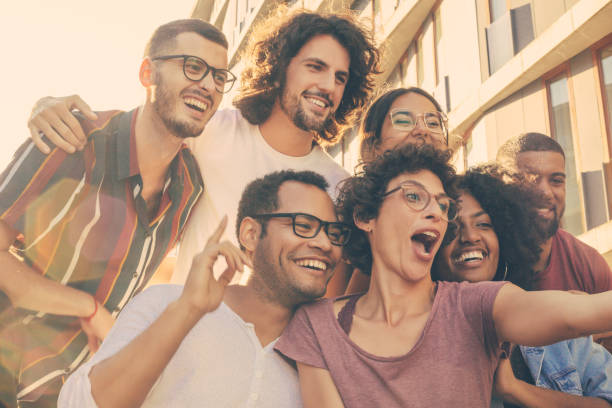 istock Funny curly haired woman in glasses taking selfie 1207455991
