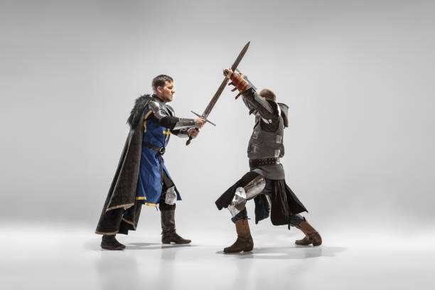 Brave armored knights with professional weapon fighting isolated on white studio background. Historical reconstruction of native fight of warriors. Concept of history, hobby, antique military art.