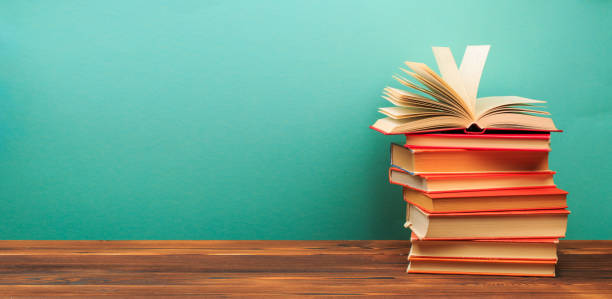 istock Opened Book on a pile of old books on blue background - Image 1207457566