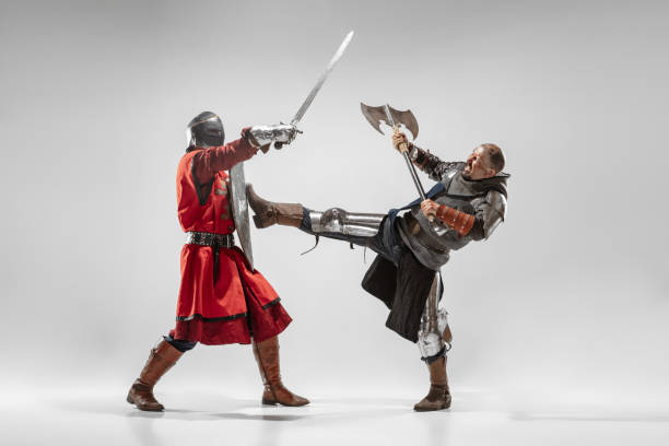 istock Brave armored knights fighting isolated on white studio background 1207458192