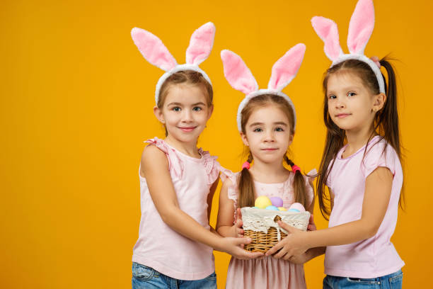 istock child girls holding basket with painted eggs. 1207458686