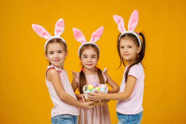 istock child girls holding basket with painted eggs. 1207458723