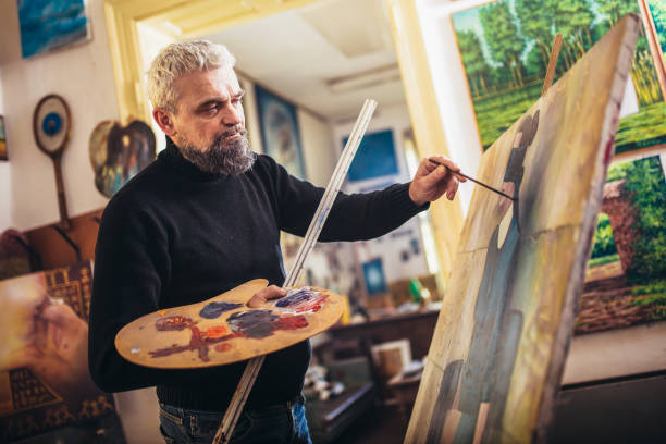 istock Mature man painting on canvas in art studio. 1207458793