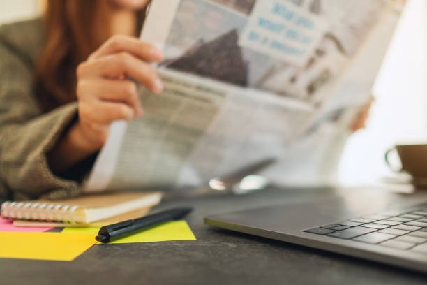 istock A business woman reading newspaper while working 1207458846