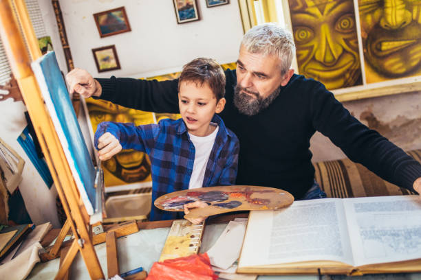 istock Father and son working and painting together in art studio 1207460158