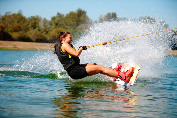 istock Excited young woman riding wakeboard 1207460213