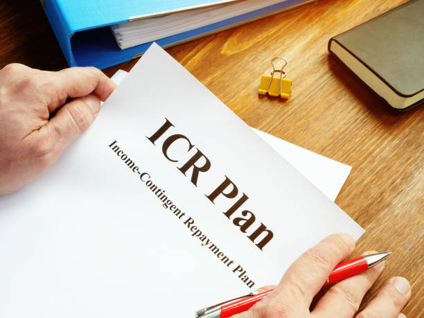 istock Man reads ICR Income-Contingent Repayment Plan. 1207460251