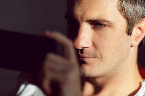 istock Young man watching something on his mobile phone 1207462371