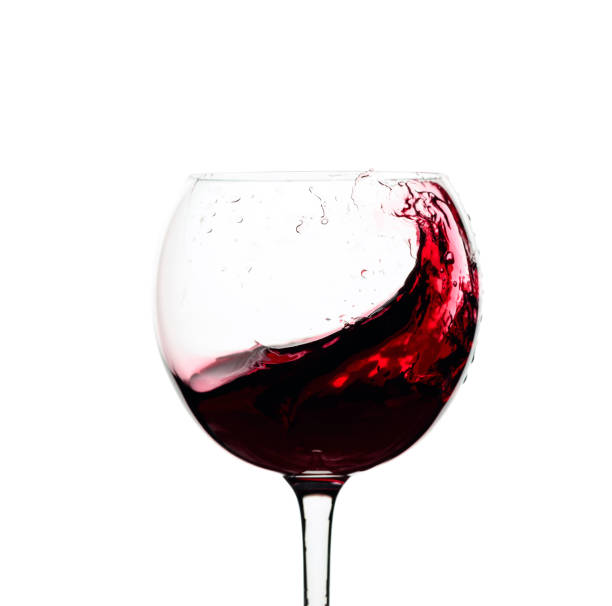 istock Splash of red wine in a glass isolated on  white. 1207462409