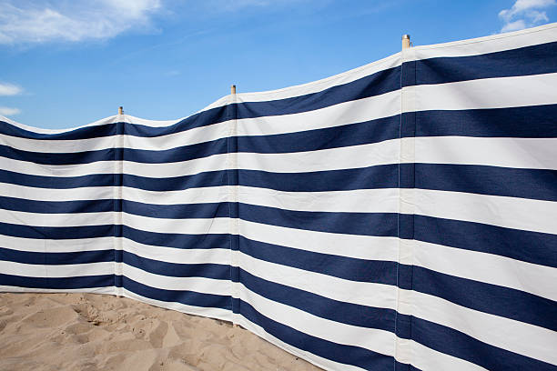 istock blue and white striped windbreak at the beach 120746243