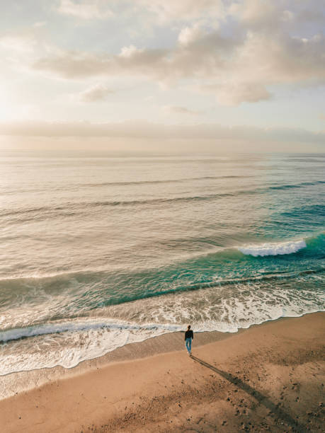 istock Woman standing on the beach 1207464053