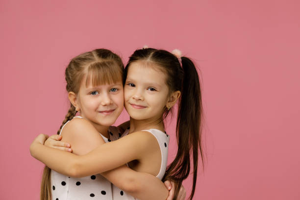 istock two beautiful little girls hugging 1207466701