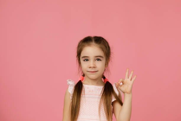 istock Cute smiling little child girl making Ok gesture 1207466904