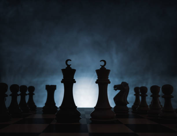 istock Chess game concept of challenge, ideas and competition. Chess figures isolated with dark background with fog and white light. 1207468569