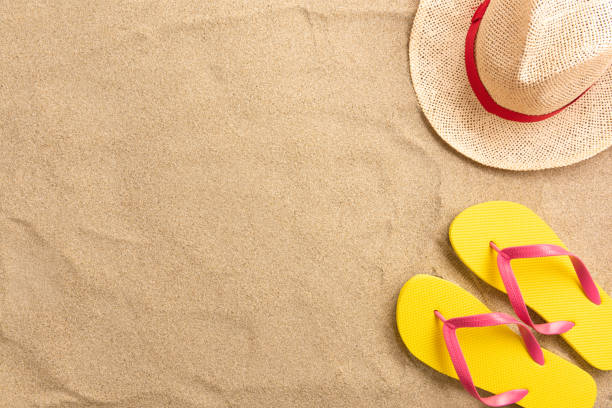 istock Flip flops, straw hat, on sand background. Beach vacation concept .Top view with copy space. 1207470246