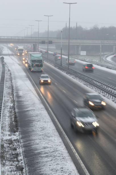 istock Moving traffic on a highway during a snow blizzard in winter 1207470384