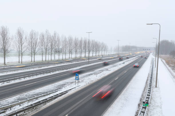 istock Moving traffic on a highway during a snow blizzard in winter 1207470402