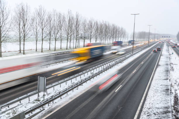 istock Moving traffic on a highway during a snow blizzard in winter 1207470476