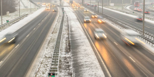 istock Moving traffic on a highway during a snow blizzard in winter 1207470508