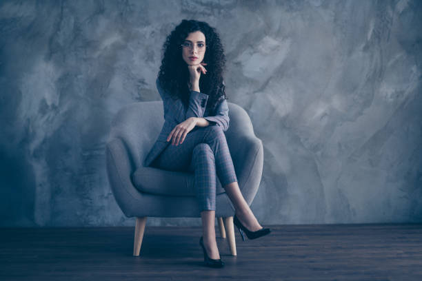 istock Portrait of her she nice-looking attractive charming classy chic serious minded wavy-haired girl psychologist sitting in chair crossed legs listening client gray concrete wall background 1207471940