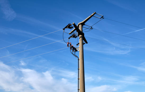 istock Close-up of high voltage pylon against blue sky 1207474662
